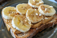 Classic and nutritious breakfast or snack featuring creamy natural peanut butter and sliced ripe bananas on toasted whole grain bread.